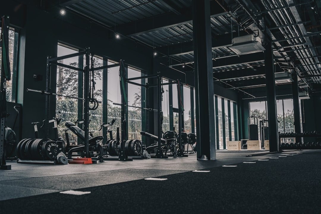 Intérieur d'une salle de musculation moderne avec racks, bancs et haltères